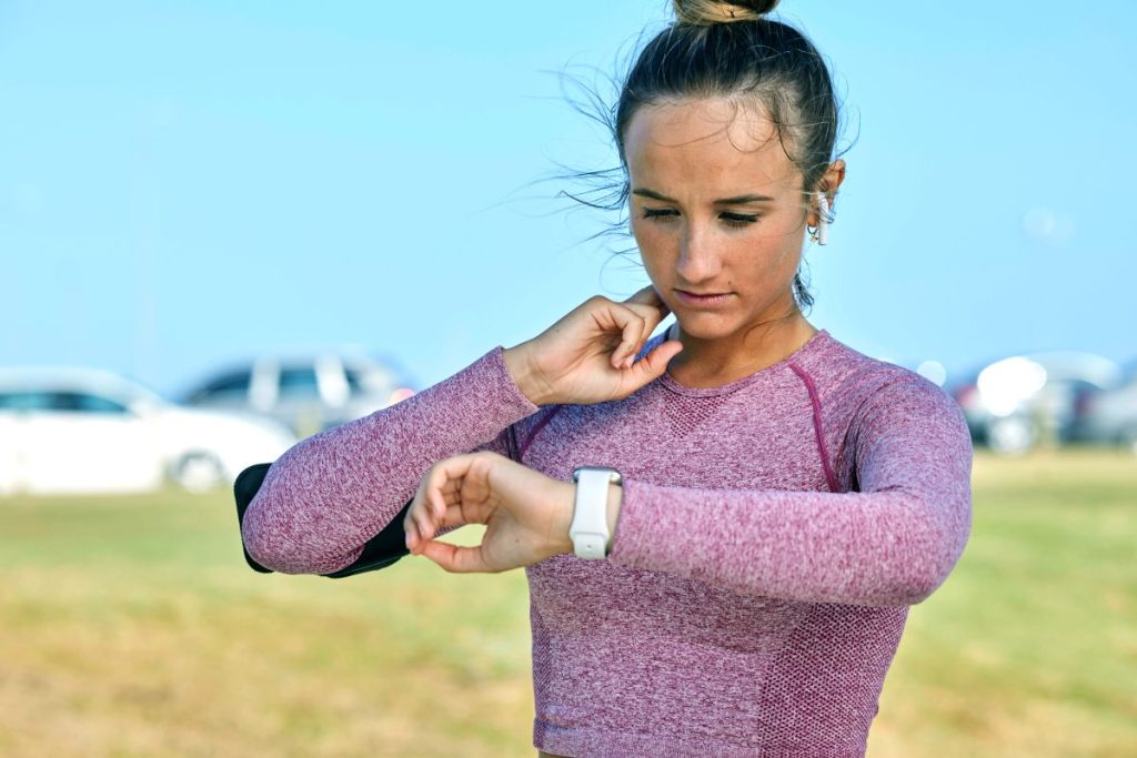 A woman checking her pulse on her smartwatch after exercising.